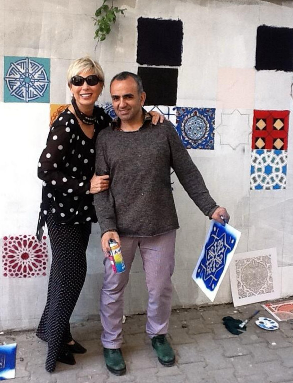 Leyla Alaton ve İsmail Acar, yarı boyalı duvarın önünde